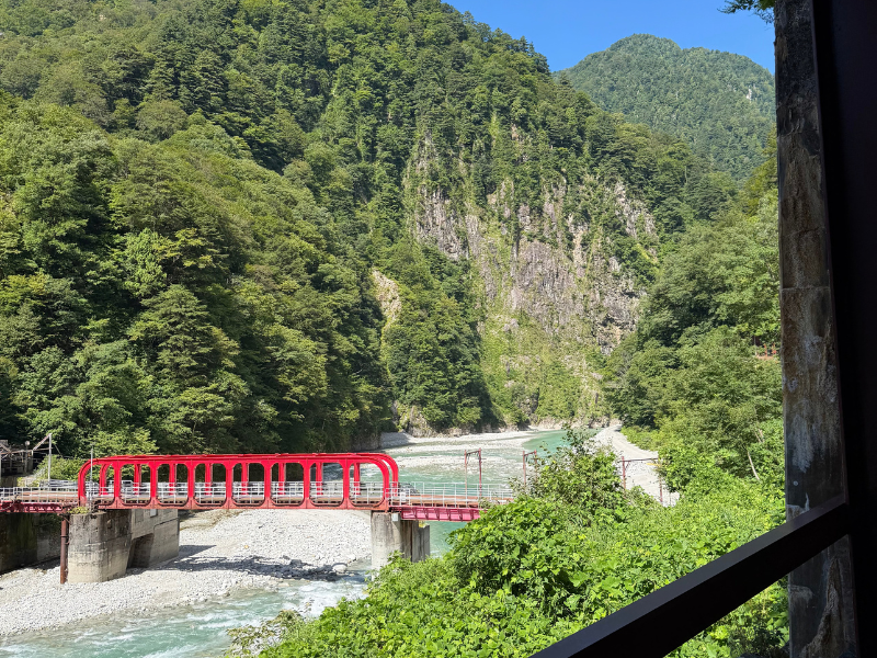 窓のない車両から見た黒部峡谷の山と川の景色